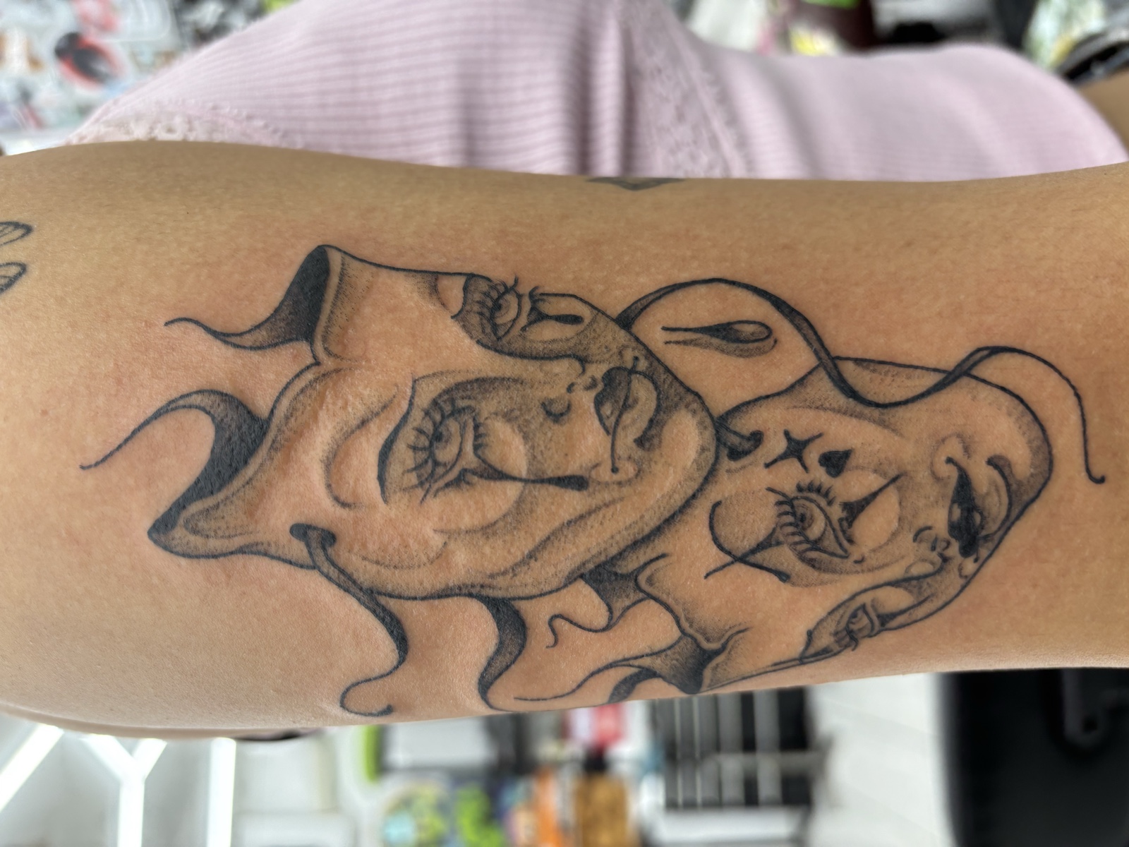 Twin theatre masks (comedy and tragedy) — black & gray illustrative drapery flowing across the arm